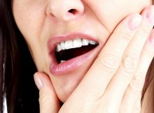 Woman with a toothpain, isolated on white